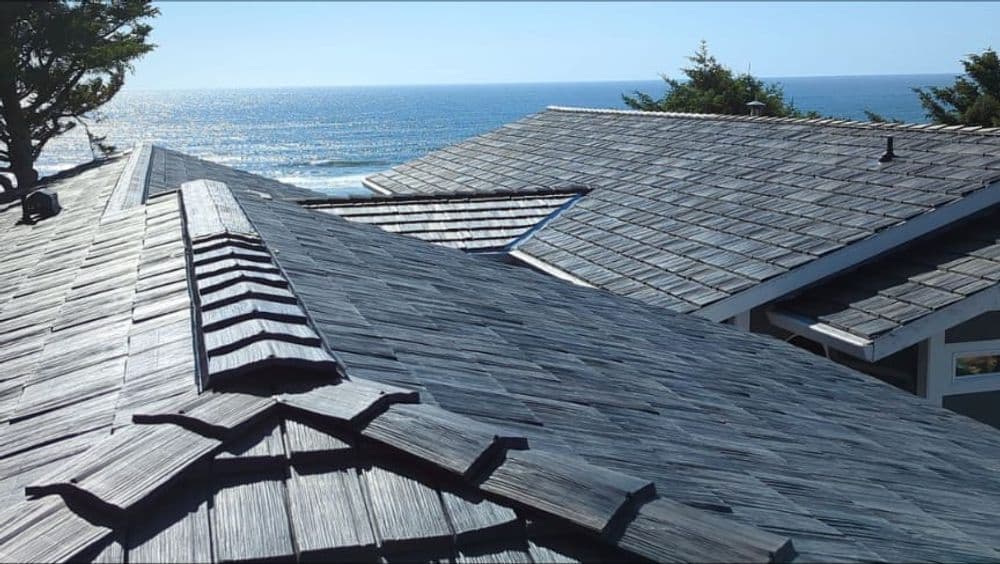 Ocean view from a rooftop with modern slate shingles and clear blue skies.