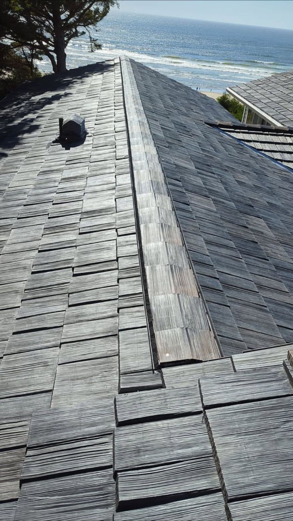Aerial view of a textured slate roof overlooking the ocean and shoreline.