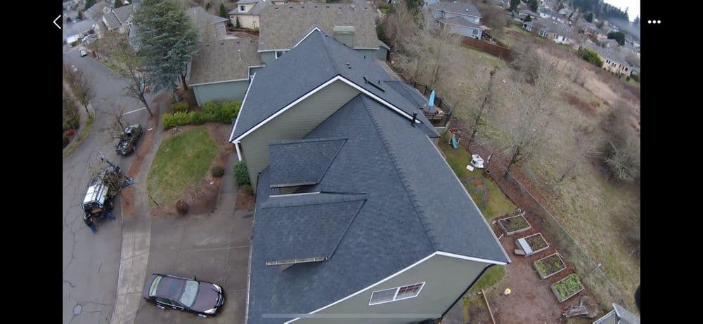 Aerial view of a residential home with a modern roof and surrounding landscape.